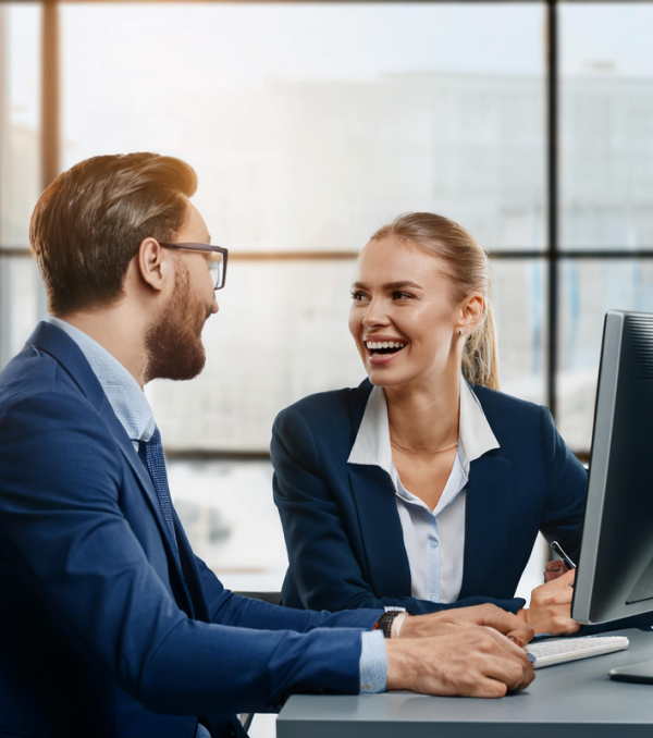 Man and woman laughing at computer