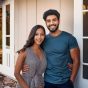 Young couple standing in front of a home