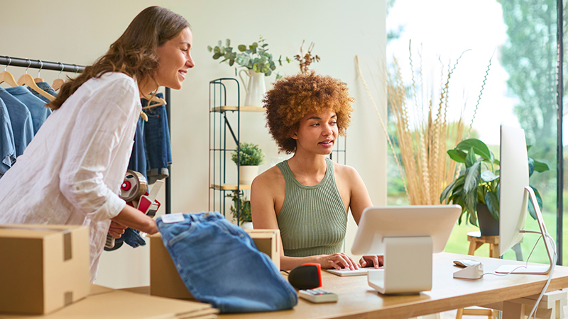 Two women working on an e-commerce website at their store