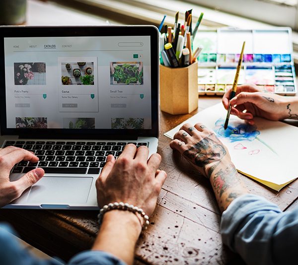 Two people working on a web design at a computer