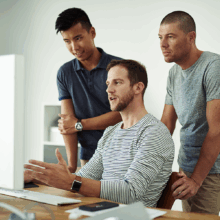 Group of men working at a computer