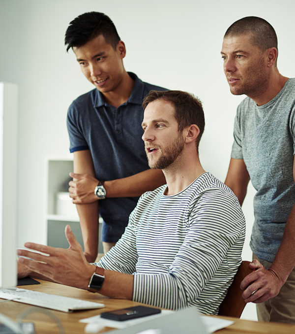 Group of men working at a computer